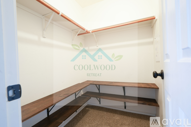 A white interior space with a wooden bench and a wall that says "COOLWOOD RETREAT".