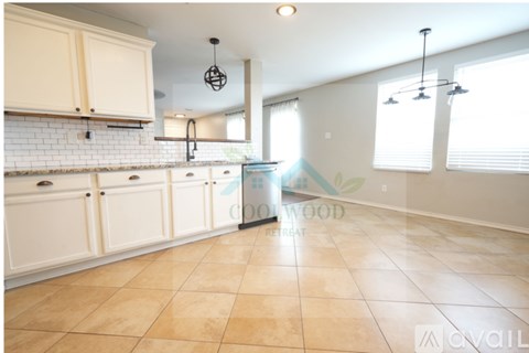 A kitchen with white cabinets and a tiled backsplash.