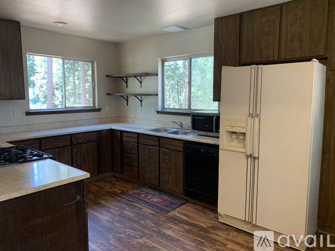 A kitchen with a white refrigerator, wooden cabinets, and a black stove top.