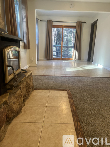 A living room with a stone fireplace and a television.