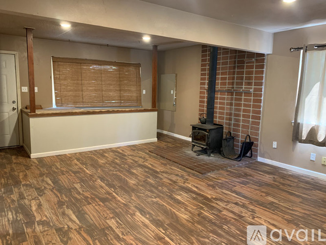 A room with wood flooring and a brick wall.