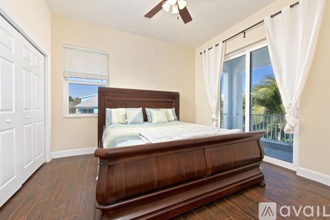 A bedroom with a large bed and a sliding glass door.