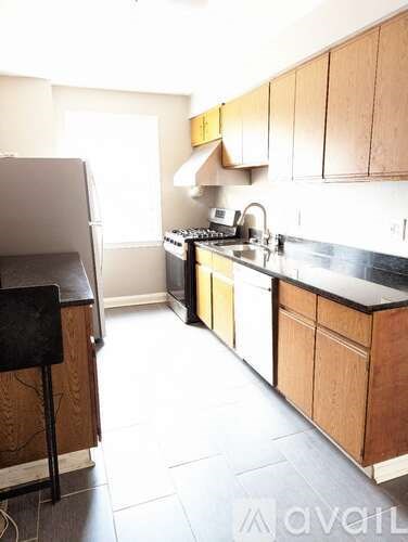 A kitchen with wooden cabinets and a black countertop.