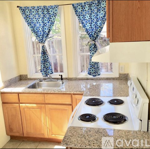 A kitchen with a granite countertop and a white stove top.
