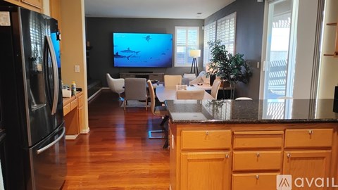 A kitchen with wooden cabinets and a black fridge.