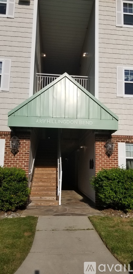 The entrance to a building with a green awning and a sign that reads "347 Hillington Bend".