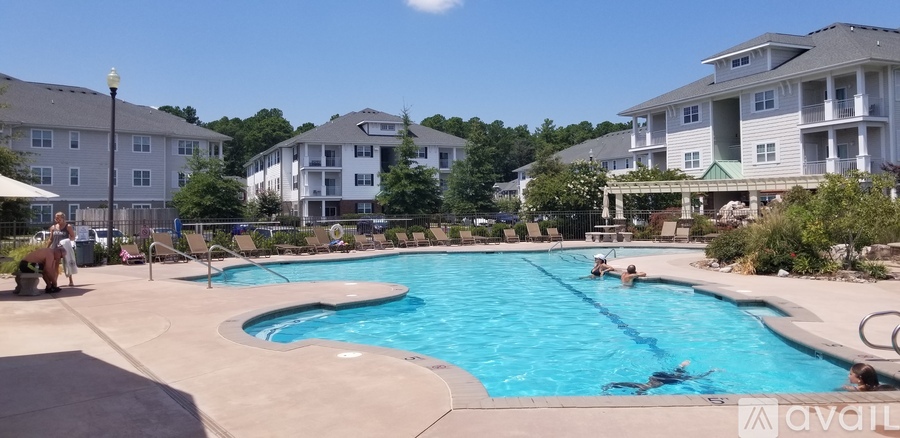 People are swimming in a pool surrounded by buildings.