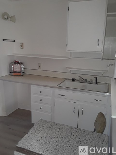 A bathroom with a sink, mirror, and cabinets.