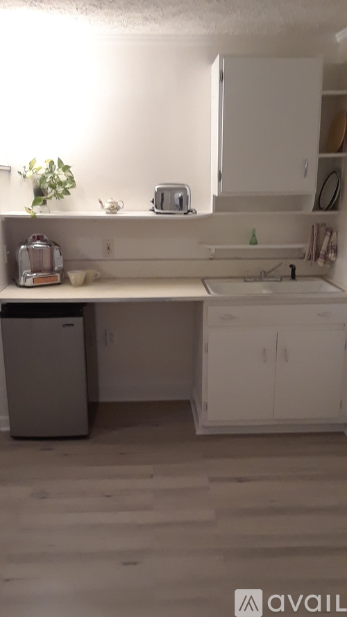 A kitchen with white cabinets and a white sink.
