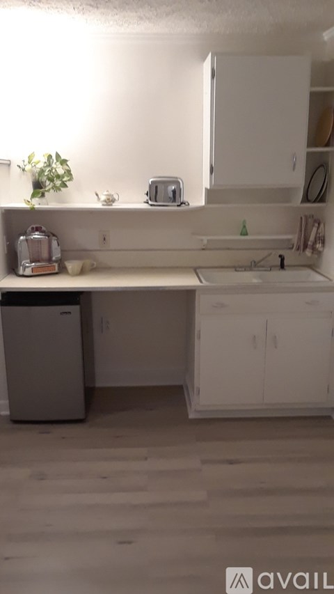 A kitchen with white cabinets and a white sink.