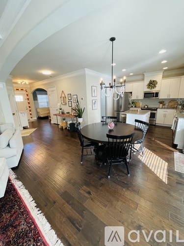 A large open plan living and dining area with a kitchen in the background.