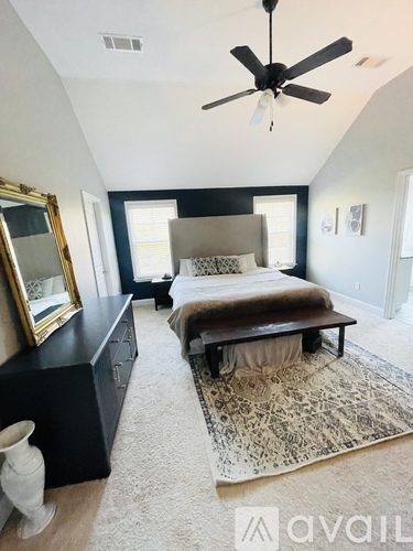 A bedroom with a bed, dresser, and mirror.