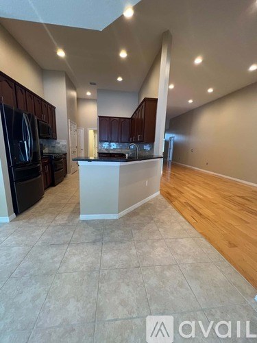 A kitchen with dark wood cabinets and a white island.