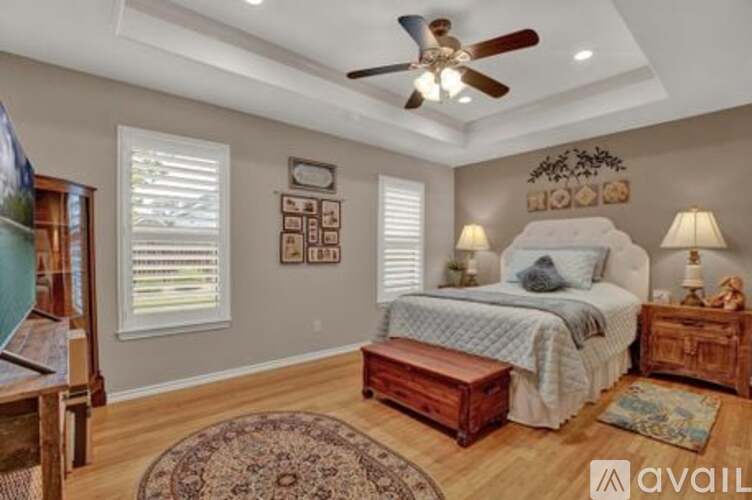 A bedroom with a bed, nightstand, and a ceiling fan.