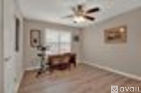 A living room with a couch and a fan.
