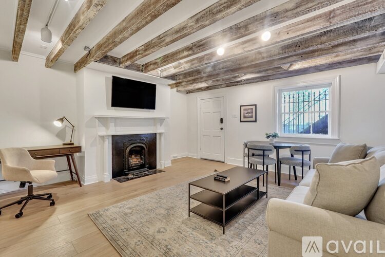 A living room with a fireplace and a television on the wall.