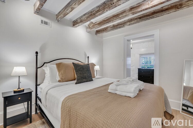 A bedroom with a large bed and a wooden ceiling.
