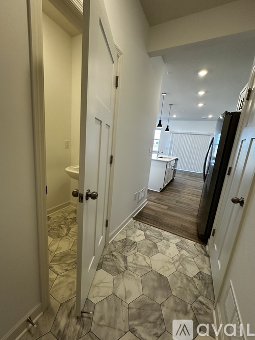 A hallway with a marble floor and white walls.
