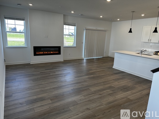 A spacious living room with a fireplace and hardwood flooring.