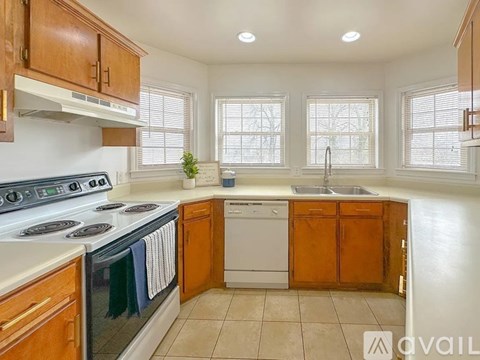 A kitchen with wooden cabinets and a stove top oven.
