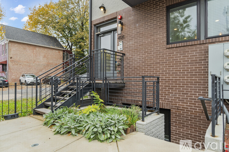 A brick building with a black metal staircase in front.