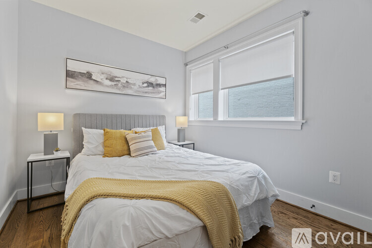 A bedroom with a large bed and a painting on the wall.
