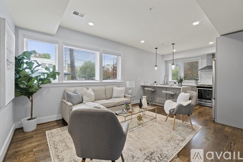 A modern living room with a grey sofa and a grey armchair.