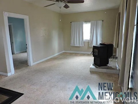 A spacious living room with a television set on a stand.