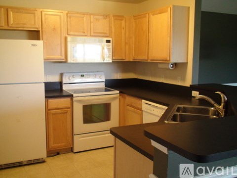 A kitchen with wooden cabinets and a white fridge.