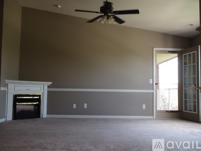 A living room with a fireplace and a ceiling fan.
