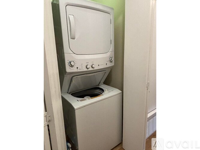 A white washing machine is sitting in a small space.