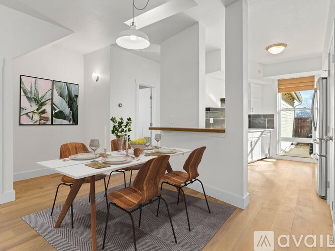 A dining room with a white table and chairs.