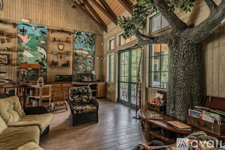 A living room with a tree growing through the floor.