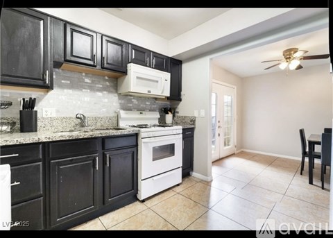 A kitchen with black cabinets and a white oven.