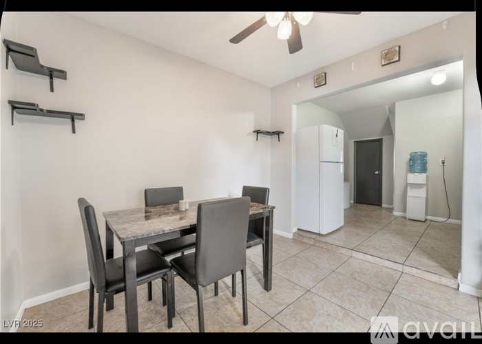 A dining room with a table and chairs.