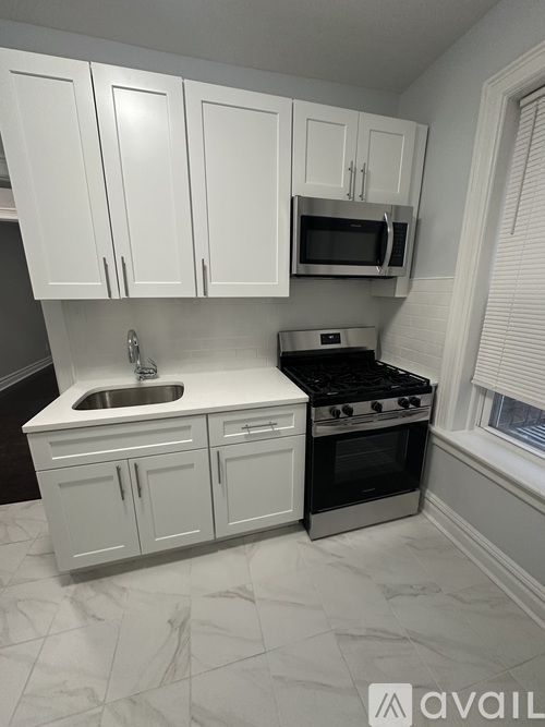 A kitchen with white cabinets and a black stove top oven.