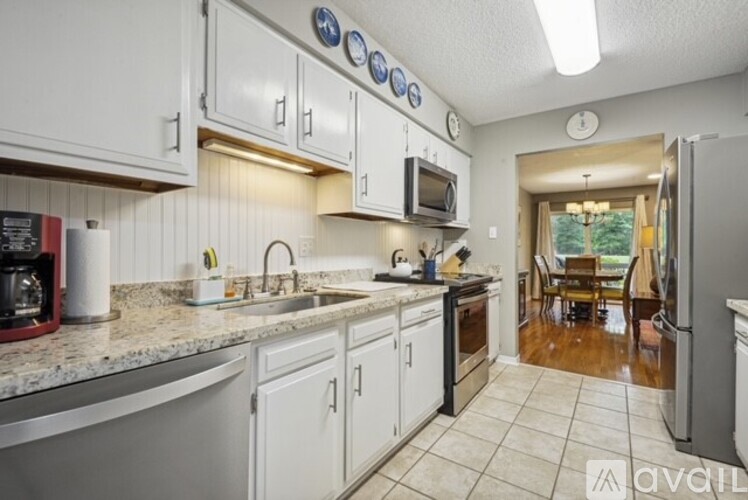 A kitchen with white cabinets and a granite countertop.