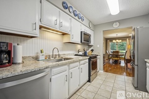 A kitchen with white cabinets and a granite countertop.