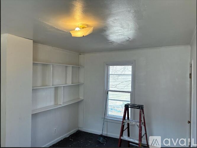 A room with a window and a ladder.
