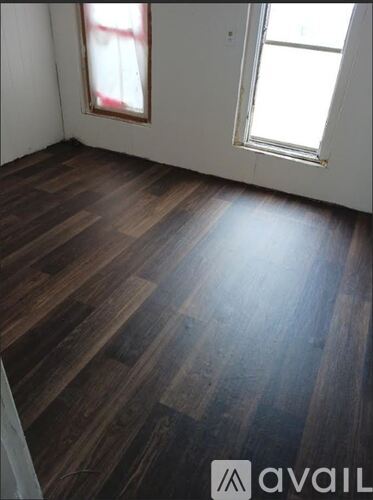 A room with wooden flooring and a window.