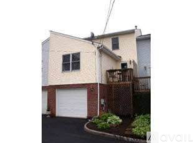 A house with a white garage door and a brown fence.