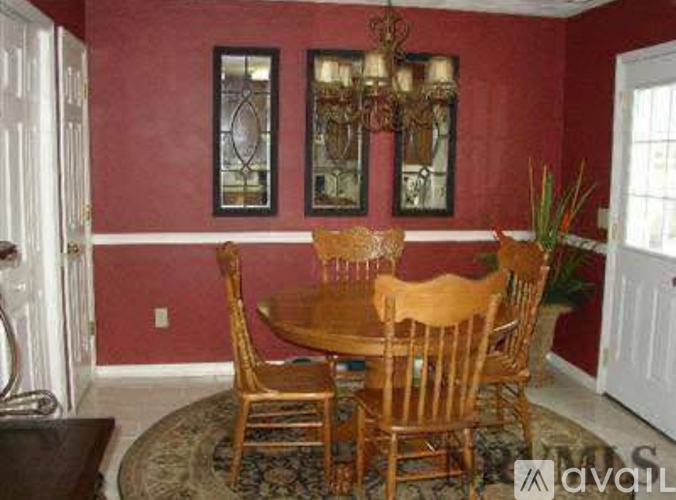 A dining room with a wooden table and chairs.