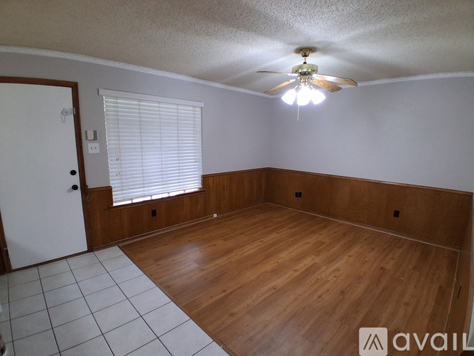A room with wooden floors and a ceiling fan.