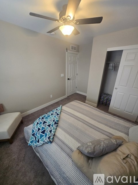 A living room with a striped couch and a ceiling fan.