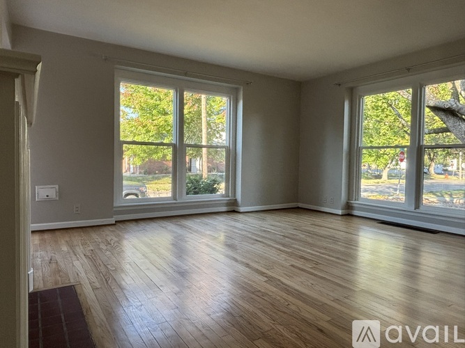 A room with wooden floors and large windows.