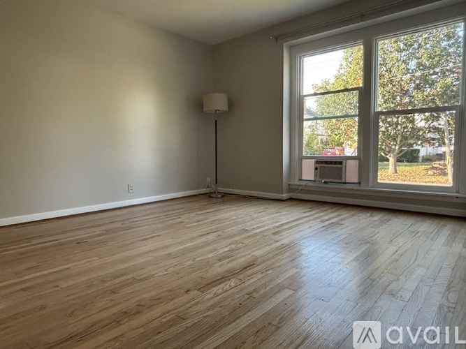 A room with wooden flooring and a large window.