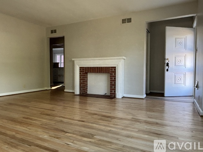 A room with a fireplace and wooden floors.