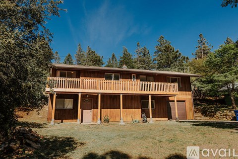 A wooden house with a balcony and a garage door.