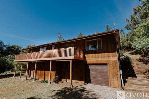 A wooden house with a balcony and a garage door.