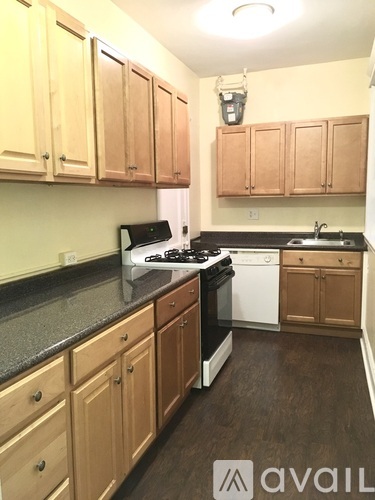 A kitchen with wooden cabinets and black countertops.